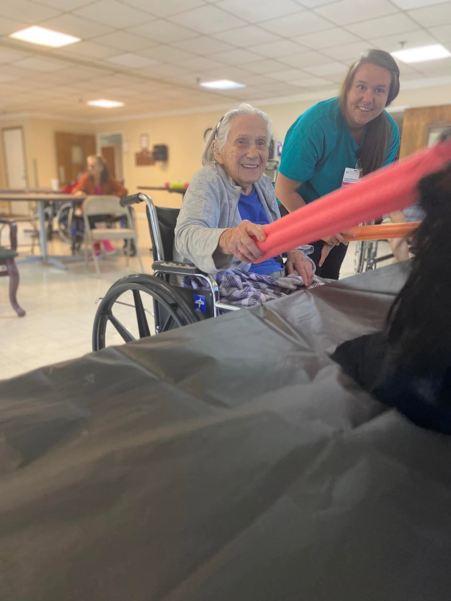 A resident enjoying a group exercise activity with a staff member